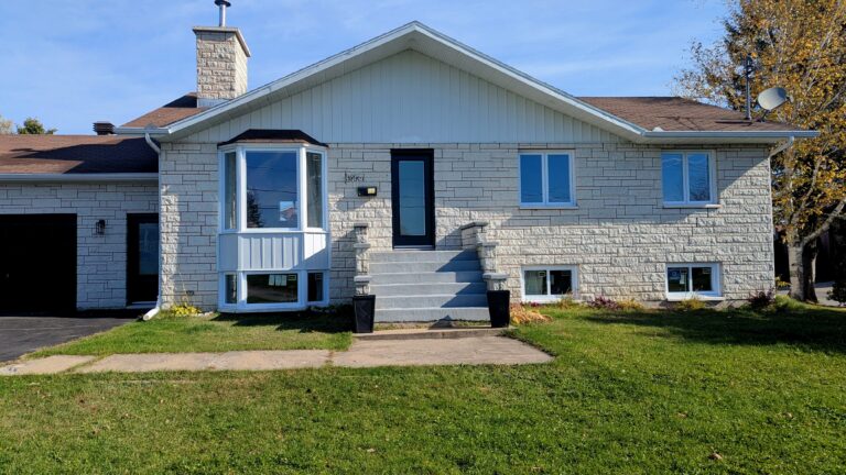 Maison avec portes et fenêtres en PVC blanc, façade en pierre, style contemporain, installation par Portes et Fenêtres BMM.